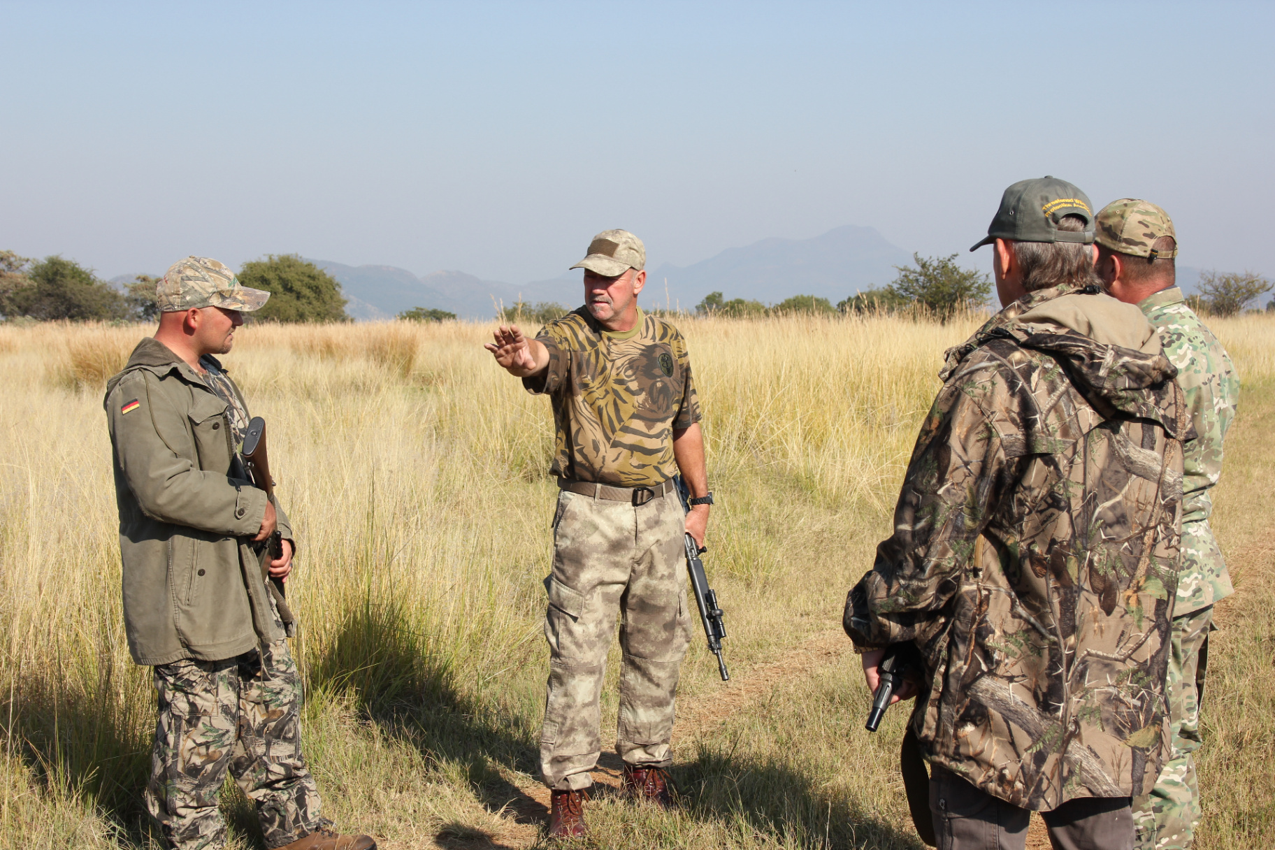 Les Brett instructing an anti-poaching team in open grassland training terrain.